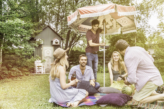 Friends having picnic in garden