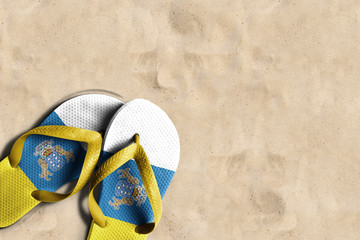 Tongs avec drapeau des îles Canaries, sur le sable de la plage