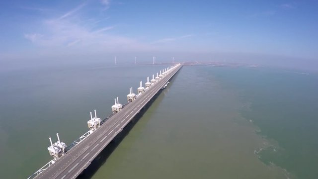 Aerial of east side of Oosterscheldekering part of Delta Werken largest of thirteen Delta Works dams and barriers in English named Eastern Scheldt storm surge barrier Netherlands Deltaworks road 4k