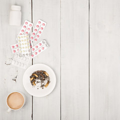 Cup of coffee, cigarettes, medical bottles and pills on white 