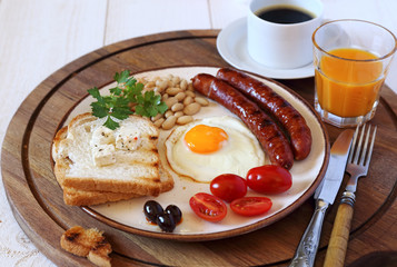 English breakfast with sausage, fried egg and baked beans