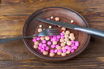 pills on a plate with knife and fork