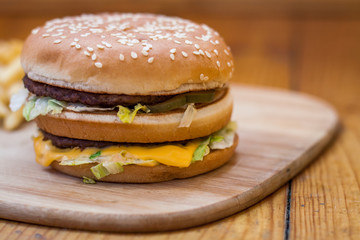 Fast food set big hamburger and french fries on wood background