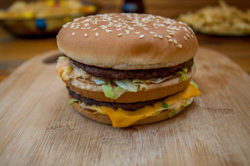 Fast food set big hamburger and french fries on wood background