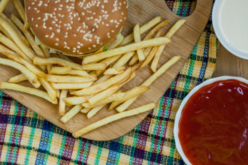 Obraz na płótnie Canvas Fast food set big hamburger and french fries on wood background