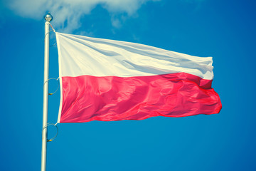 Polish flag on blue sky background, vintage look