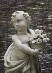 Cupid with a Bouquet of Flowers: A decorative garden statue of Cupid carrying a small bouquet of flowers