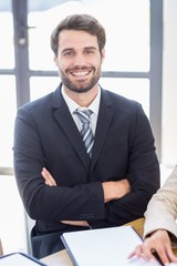 A businessman is smiling and posing