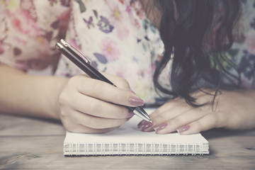 woman writes on the notepad