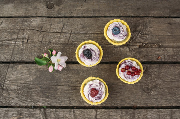 Blueberry  cupcakes with berries  and apple flowers on the wooden old planks