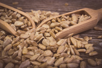 Vintage photo, Sunflower seeds with spoon on wooden background