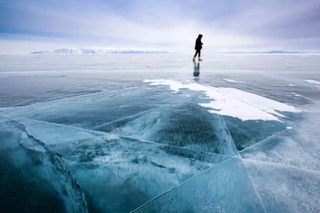 Crédence de cuisine en verre imprimé Glaciers Girl photographer walking on cracked ice of a frozen lake Baikal