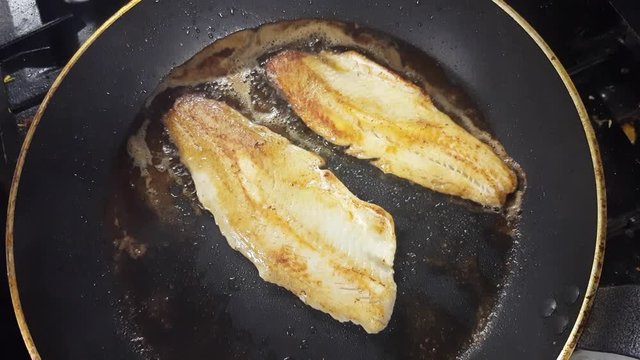 Frying zander or pike-perch fillets, on a frying pan, in slow motion