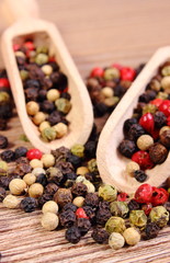 Fresh colored pepper with spoon on wooden background