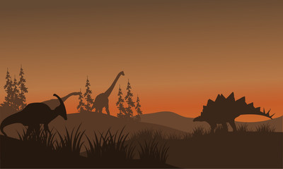 Silhouette oof many dinosaur in hills