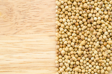 coriander seeds on wood.