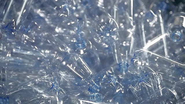 Empty plastic bottles for water are moving on the conveyor