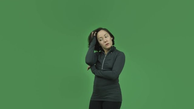 caucasian sporty girl isolated on green screen thinking scratching head