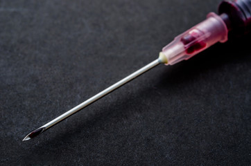 Blood in needle on black.