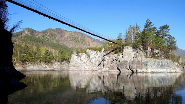 Hinged bridge to the monastery on Patmos island on river Katun in Chemal, Altai, Siberia, Russia