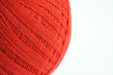 Close up to red yarn ball on white background, front focus