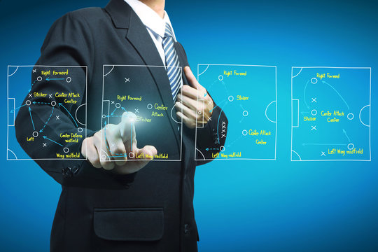 Plan of soccer manager pointing to strategy tactical board