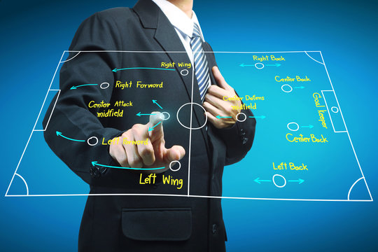 Plan of soccer manager pointing to strategy tactical board - Powered by Adobe