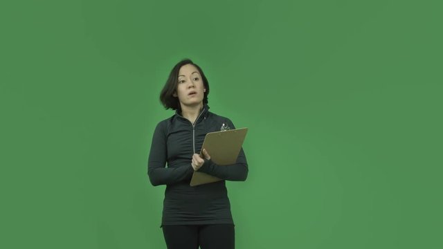 caucasian sporty girl isolated on green screen with check list