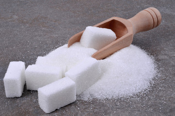 Petite pelle en bois avec des pierres de sucre et du sucre en poudre