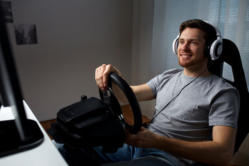 man playing car racing video game at home