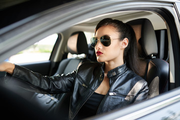 Fototapeta na wymiar Confident woman in sunglasses driving to work