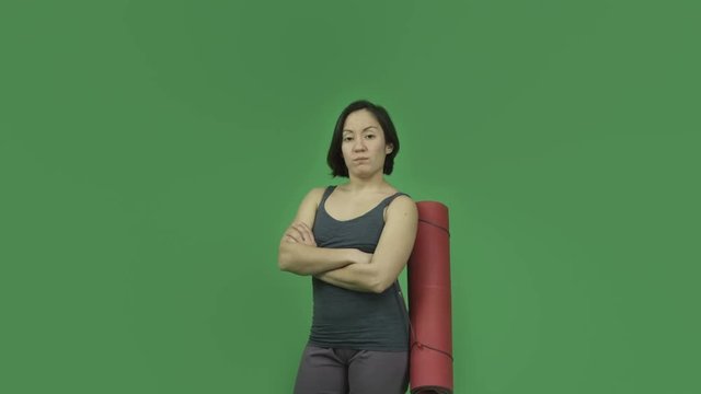 caucasian sporty girl with yoga mat isolated on green screen upset
