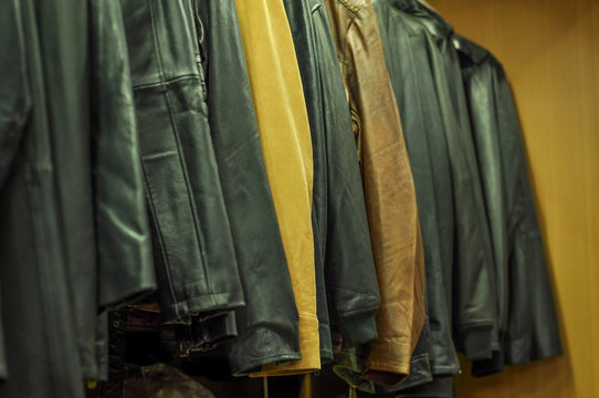 Hanging leather jackets on clothes rack in leather shop
