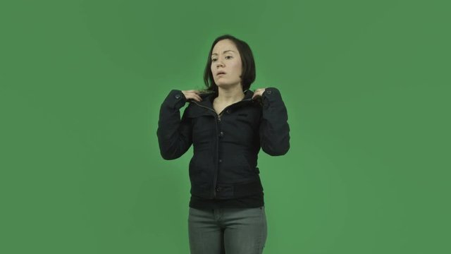 caucasian girl with winter jacket isolated on green screen thinking scratching head
