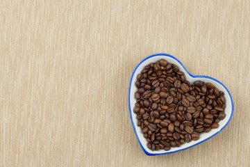 Roasted coffee beans on the kitchen table. Fresh coffee. Preparation of hot coffee. Refreshing drink. Sales of coffee beans. Advertising for coffee shop. We love fresh coffee.
