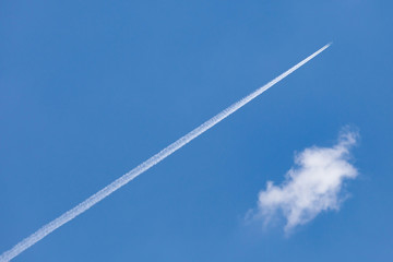 The airplane trail speed through cleared blue sky.