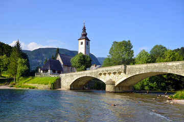Fototapeta na wymiar Old St. John church and stone bridge at Bohinj lake, Slovenia