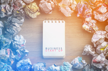 business startup word on blank page paper with crumpled paper
