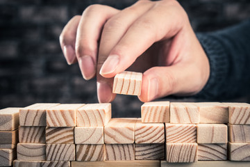 木製のブロックを積み上げている手