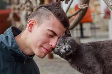 Friends at first sight, young man befriending a cat, color version