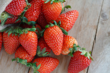 strawberries in small sack on wooden table background