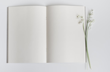 Open empty book with lily of the valley.