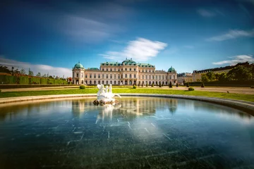 Deurstickers View on Upper Belvedere palace with fontain in Belvedere historic building complex in Vienna. Long exposure technic with blurred clouds and glossy water © rh2010
