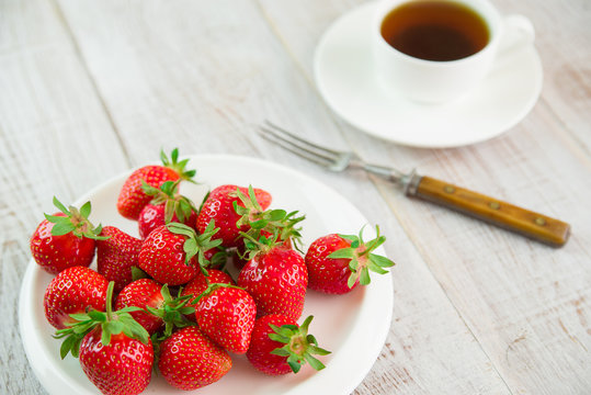 Ripe strawberry fruits on a white plate