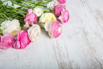 Fototapeta na wymiar Ranunkeln Blumenstrauß auf einem Holztisch 
