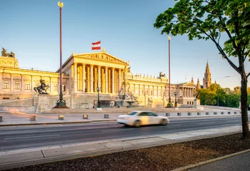  Austrian parliament building with Athena statue on the front in Vienna on the sunrise. Long exposure image technic with burred car © rh2010