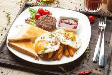 Minced beef on the grill with  fried eggs, crisp and toast.