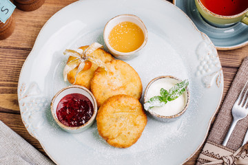 Homemade delicious cottage cheese pancakes with jam and honey 