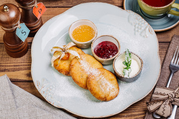 Homemade delicious cottage cheese pancakes with jam and honey on