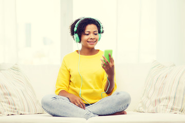 happy african woman with smartphone and headphones